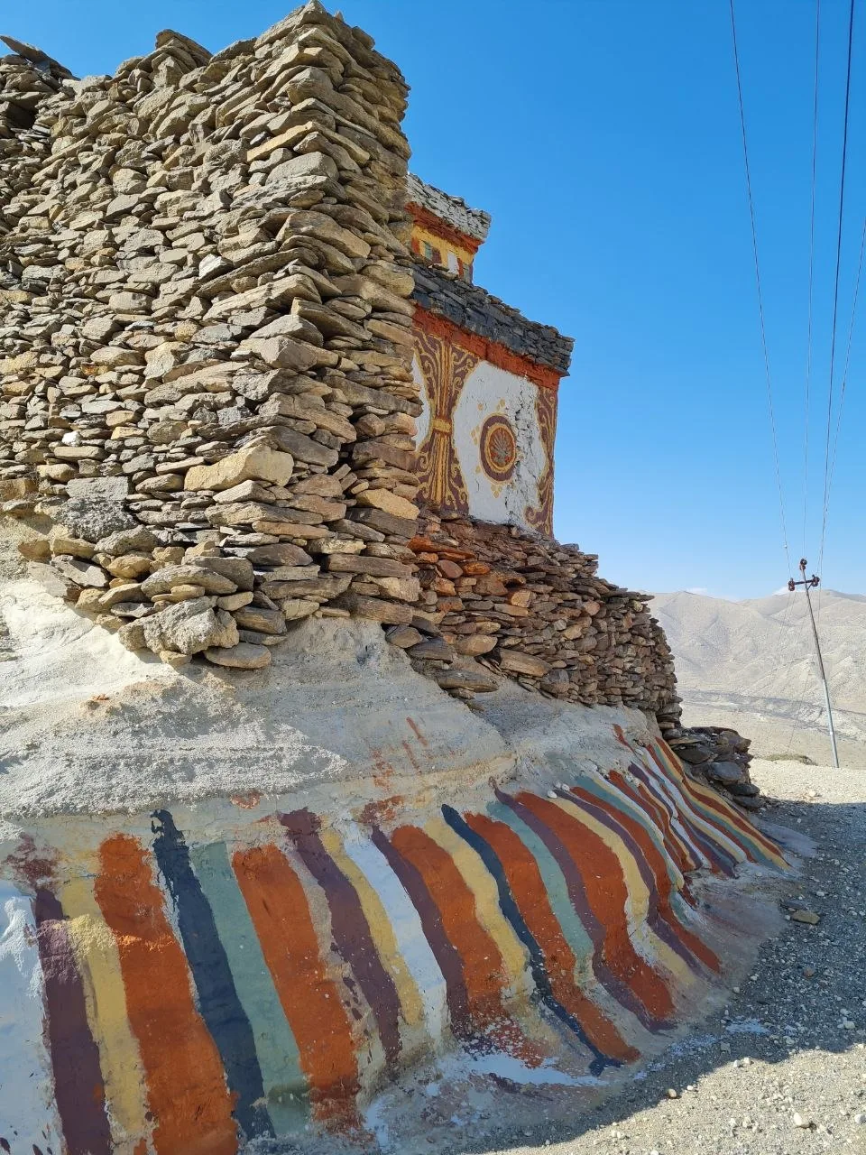 Painted chorten with Tibetan Buddhist motifs along the Mustang circuit trail.