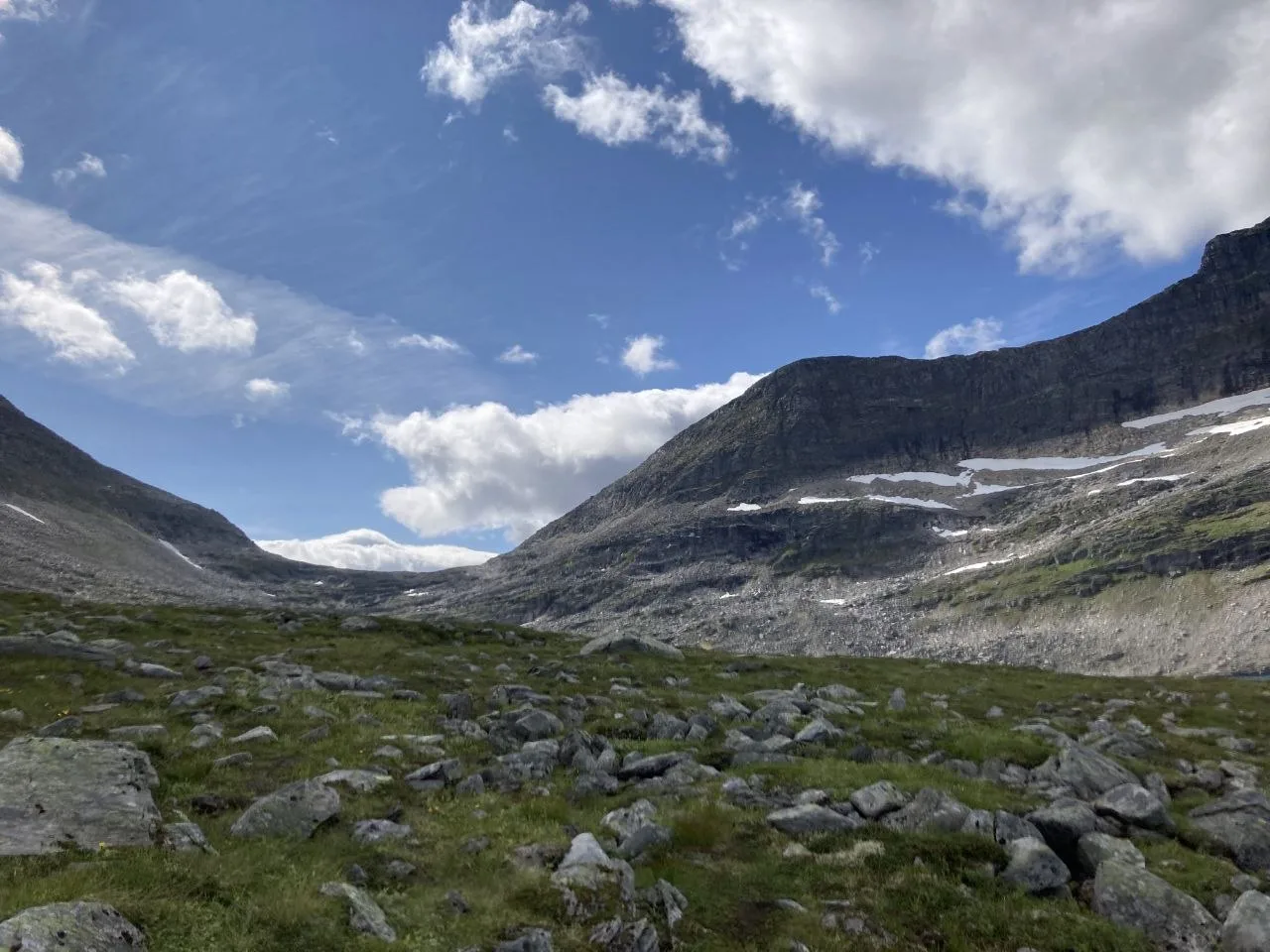 Rock-strewn valley with lingering snow patches