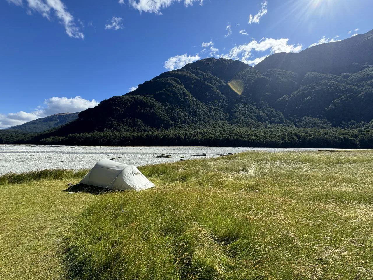 A solo tent pitched on river flats along the Rees-Dart Track, New Zealand.
